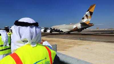 Abu Dhabi Airport officials watch an Etihad Airbus A380 taxi at Abu Dhabi International Airport. Ravindranath K / The National