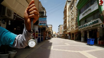 A man holds a pocket watch at noon, as he shows the time while posing for photo at an almost empty market near the Imam Ali shrine, during the coronavirus disease outbreak, in Najaf, Iraq. Reuters