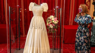 Britain's Princess Beatrice of York stands alongside her wedding dress, which was originally worn by Britain's Queen Elizabeth in the 1960s, ahead of it going on public display at Windsor Castle, Windsor, Britain. Reuters