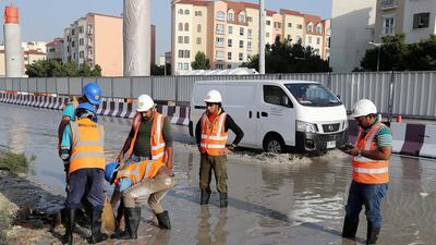 Workers at the under construction Dubai Metro site clear the blocked drainage in the Discovery Gardens area of Dubai. Pawan Singh / The National