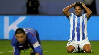 Malaga’s Eliseu, right, sums up his team’s season this year as he holds his head in despar as another goal-scoring chance goes begging.