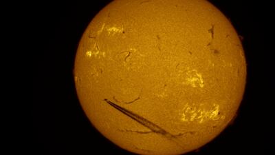In this photo taken by telescope, which shows solar activity zones, an airliner is silhouetted against the Sun over St Petersburg, Russia. AP