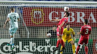 Gibraltar defender James Bosio heads the ball past his own goalkeeper Deren Ibrahim. Jose Manuel Ribeiro / AFP