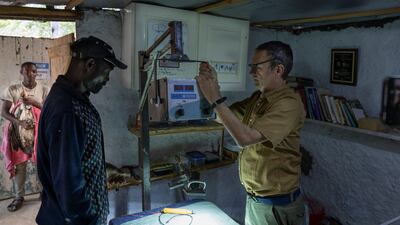 Mr Thomsett, right, sets up a portable imaging machine with the help of a raptor technician at Soysambu