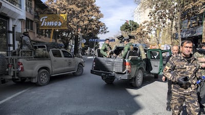 Security forces stand outside Slice Bakery in Share-Naw, where one of the rockets hit, damaging a delivery van and injuring several people. Stefanie Glinski for The National
