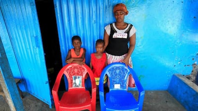 Mariama Bah and her children Kadijatu Jalloh, centre, and Binta Jalloh pose for a family portrait at their home in West Point, Monrovia, Liberia. The empty chairs symbolise Mariama’s late husband and son, Alhaji Cellou Jalloh and Alpha Umaru Jalloh, who died of the Ebola virus. Ahmed Jallanzo / EPA