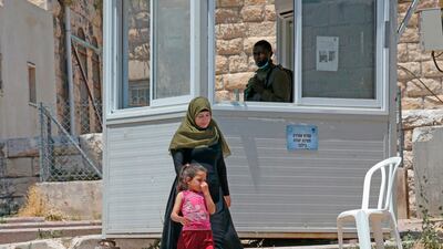 Palestinians walk past an Israeli military guard post to reach their homes on al-Shuhada street, in the H2 area of the city of Hebron, in the occupied West Bank. AFP