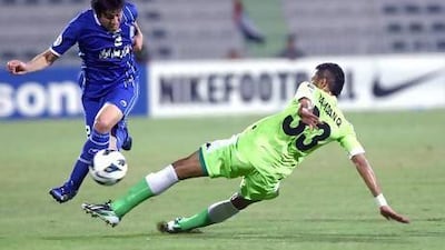 Esteghlal's Khosro Heidari, left, and Al Shabab's Ali Hamdan in action during their Asian Champions League match in Dubai. Satish Kumar / The National