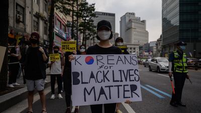 Activists hold placards as they attend a rally in support of the 'Black Lives Matter' demonstrations in the US, during a march in the Myeongdong district of central Seoul on June 6, 2020. AFP