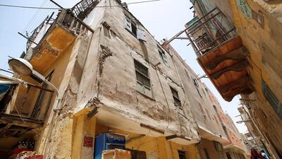 A woman walks between old homes in Al Assal, one of the oldest slums in the Shubra district of Cairo. Amr Abdallah Dalsh/Reuters