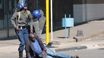 Zimbabwe Republic Police (ZRP) drag an injured protester. EPA