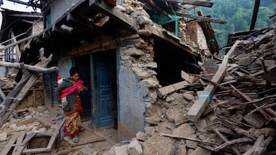 A woman stands in shock in her collapsed house after an earthquake hit Jajarkot, Nepal. Reuters