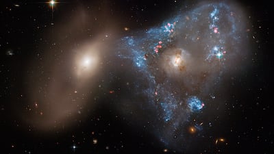 An image of two galaxies colliding, fuelled an unusual triangular-shaped star-birthing. Captured by the Hubble telescope in 2022, the interacting galaxies are called Arp 143. Photo: Nasa
