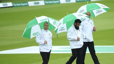 The umpires come out for their final pitch inspection before calling a halt to the day due to the rain. Getty Images