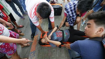 An injured protester who was run over by a Philippine National Police van waits for treatment.