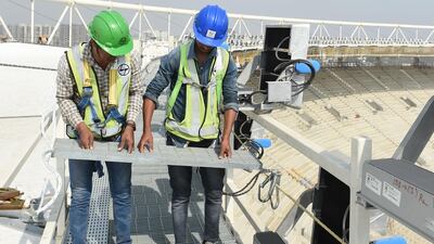 Officials check safety metal grills at the construction site of the new cricket stadium in Motera. AFP