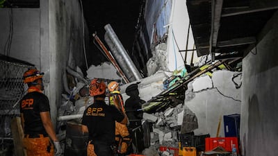 Rescue personnel assess a heavily damaged structure in General Santos. AFP