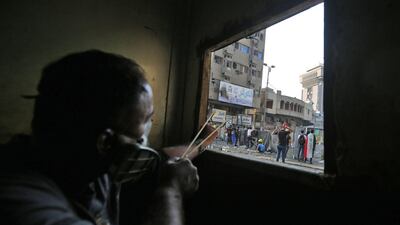 An Iraqi protester uses a slingshot to hurl stones amid clashes with security forces at Baghdad's Khallani square during ongoing anti-government demonstrations. AFP