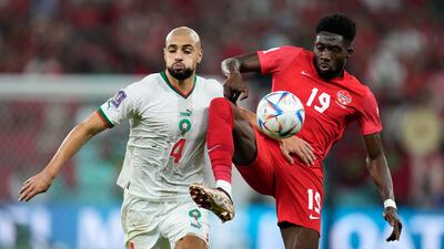 Morocco's Sofyan Amrabat, left, and Alphonso Davies of Canada battle for possession. Goals from Hakim Ziyech and Youssef En-Nesyri ensured the North Africans finished top of Group F. AP
