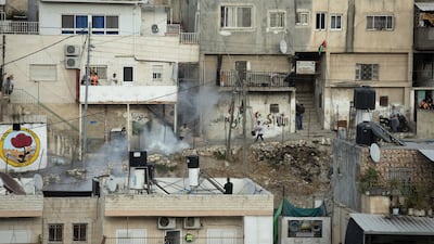 Palestinians run from tear gas fired by Israeli police during clashes in the Silwan neighborhood of east Jerusalem. AP