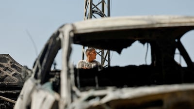 A Palestinian man surveys destroyed cars that West Bank residents say were burnt by Israeli settlers overnight in Jalud. Reuters