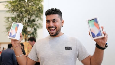 A customer poses for a photo with the new iPhone X outside the Apple store at Dubai Mall. Mahmoud Khaled / EPA