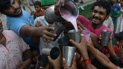 Pakistani Muslim devotees receive a sweet drink to break their fast during the Muslim fasting month of Ramadan in Lahore on June 19, 2015. Islam’s holy month of Ramadan is celebrated by Muslims worldwide. Arif Ali / AFP photo