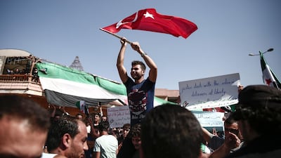 A Syrian man waves a Turkish flag during a demonstration against the government in the rebel-held town of Atareb in the western countryside of Aleppo. AFP