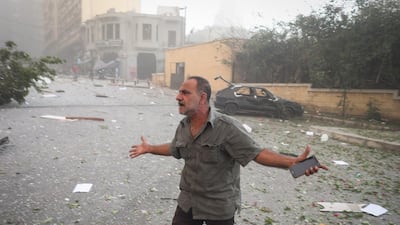 A resident stands in the street by a destroyed car, following the explosion near by at the port of Beirut. Bloomberg