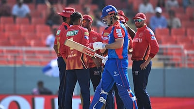 Delhi Capitals' Mitchell Marsh walks back to the pavilion after his dismissal, caught by Rahul Chahar off the bowling of Arshdeep Singh for 20 runs. AFP