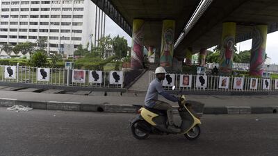 A man drives rides past portraits of some of the Chibok schoolgirls abducted by Boko Haram five years ago at Falomo roundabout in Lagos. AFP