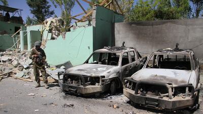 FILE PHOTO: A member of the Afghan security forces stands guard next to damaged army vehicles after a Taliban attack in Ghazni city, Afghanistan, August 15, 2018. REUTERS/Mustafa Andaleb/File Photo