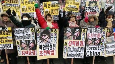 Protesters holding portraits of North Korean leader Kim Jong-il and his son Kim Jong-un shout slogans during an anti-North Korea rally near the US Embassy in Seoul yesterday.