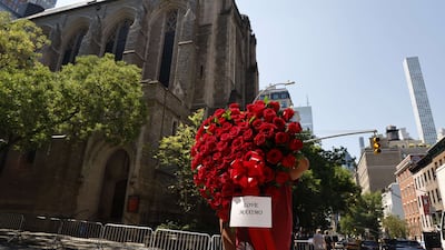A mourner holds roses outside Trump's funeral at St Vincent Ferrer Roman Catholic Church on July 20 in New York City. AFP