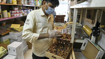 Hanif Suleiman arranges boxes at Royal Dates in the Mina market, Abu Dhabi. Khushnum Bhandari for The National