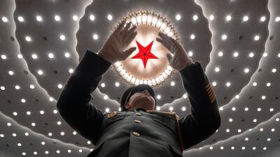 A Chinese military musical conductor leads the band at the closing ceremony of the National People's Congress in Beijing's Great Hall of the People. AP