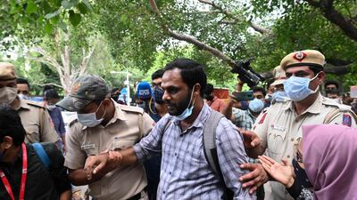 Police officials detain a student activist during a protest outside the Assam Bhawan in New Delhi against a government eviction drive that turned violent and resulted in the deaths of two people in Assam. AFP