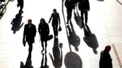 People walk through Canary Wharf in London's financial district.