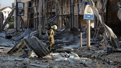 Ukrainian rescuers in the ruins of a car dealership in Kyiv after a barrage of Russian missiles fell on the capital on June 2. EPA