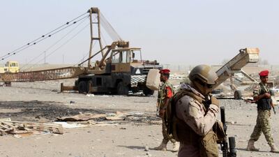 Pro-government fighters stand guard outside a damaged warehouse in Hodeida. AFP.