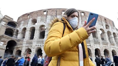 A pedestrian wearing a protective face masks walks past the Colosseum in Rome, Italy. Greece and Italy are expected to face the largest financing gaps of around 15 per cent of GDP due to ageing population. Bloomberg