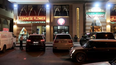 People place orders from their cars at Lebanese Flower restaurant on Muroor Road. Ravindranath K / The National