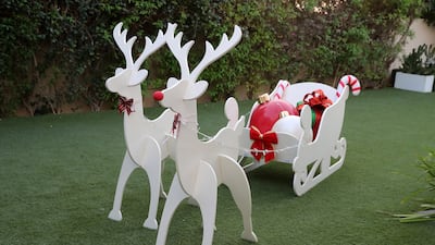 A life-size wooden reindeer and sleigh out back