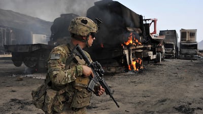 A US soldier investigates the scene of a Taliban suicide attack that set several Nato military vehicles ablaze at the Afghan-Pakistan border crossing in Nangarhar province, on June 19, 2014. AFP