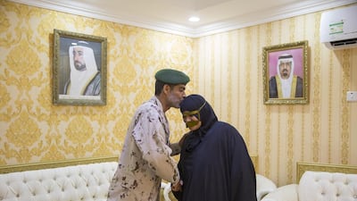 Sheikh Mohammed bin Zayed, Crown Prince of Abu Dhabi Deputy Supreme Commander of the Armed Forces, greets the son of Amna Salem Hamdan Al Marashda (not shown), whilst visiting her home in Kalba.