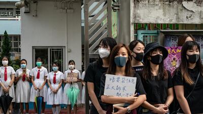 Students and alumni of Kit Sam Lam Bing Yim Secondary School stand as they form a human chain during a protest. Getty Images