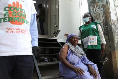 A woman waits near a mobile vaccination centre after receiving her Covid vaccine during a prevention campaign in Abidjan, Ivory Coast, in July 2021. Reuters