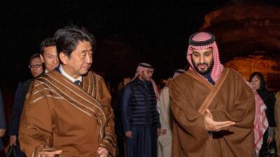 Mr. Abe wears a traditional costume as he walks with Crown Prince Mohammed bin Salman during a meeting in Riyadh.