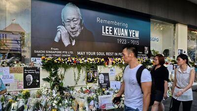 Pedestrians walk past a tribute corner for Singapore's late former prime minister Lee Kuan Yew on March 27, 2015. Roslan Rahman/AFP Photo