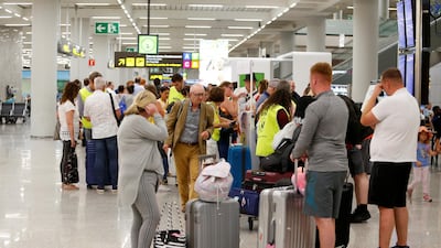 Passengers talk to Civil Aviation Authority employees at Mallorca Airport, in Palma de Mallorca, Spain. Reuters